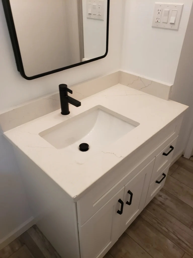 Bathroom vanity with white countertop and sink.