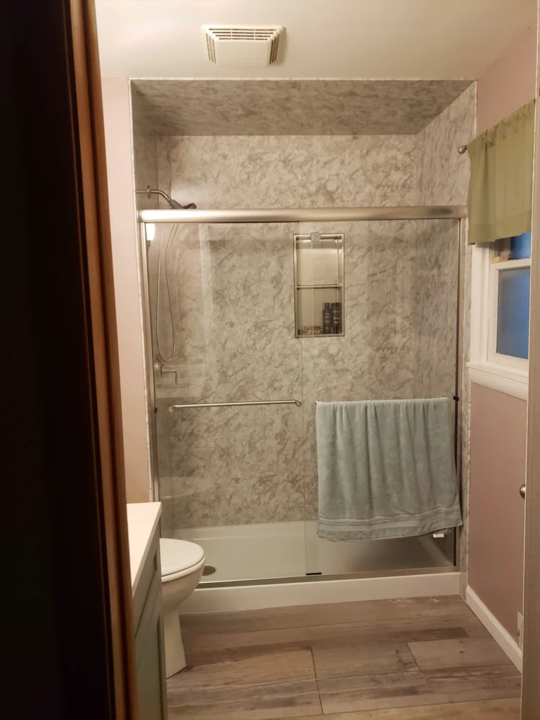 Modern bathroom with shower and towel rack.