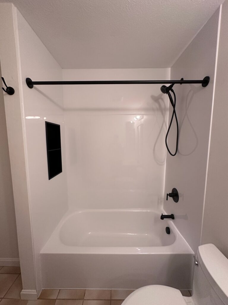 White bathroom with bathtub and showerhead.