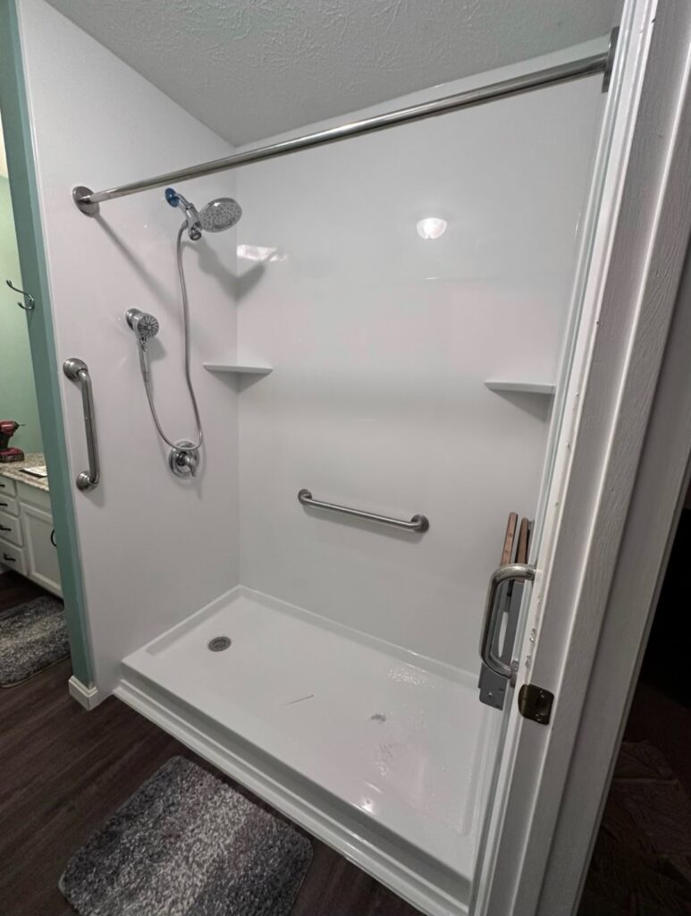 Accessible shower with grab bars and shelves.